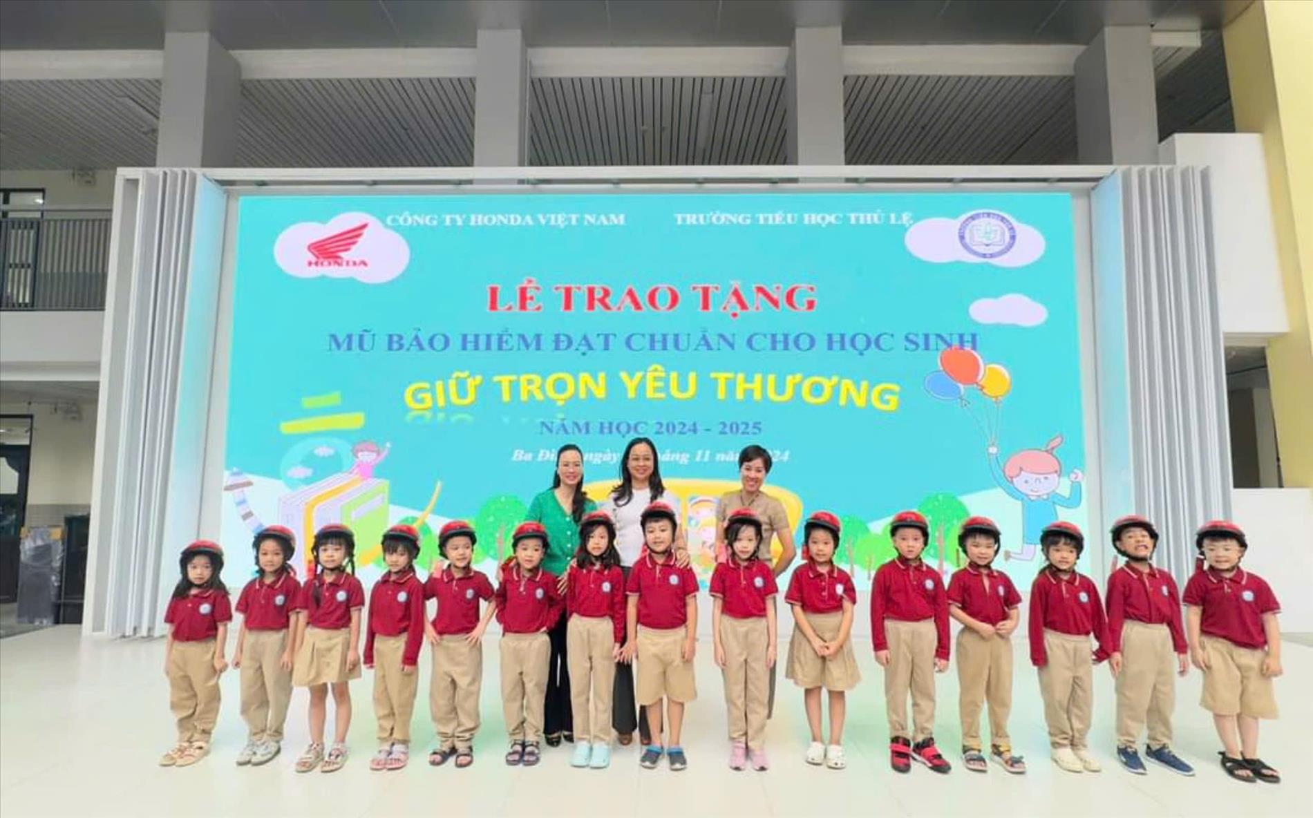 Các bạn học sinh lớp 1A trong Lễ trao tặng mũ bảo hiểm đạt chuẩn cho học sinh.