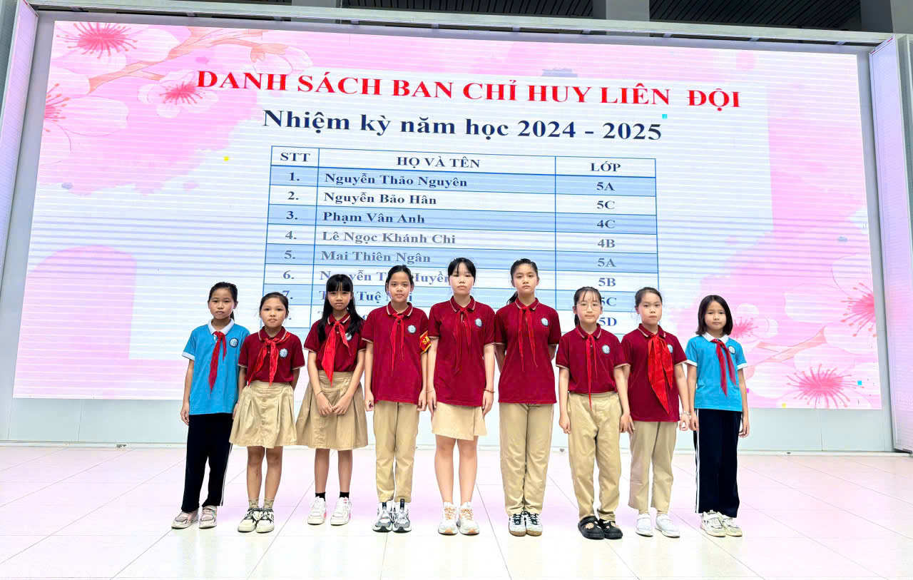 A group of children standing in front of a large sign
Description automatically generated