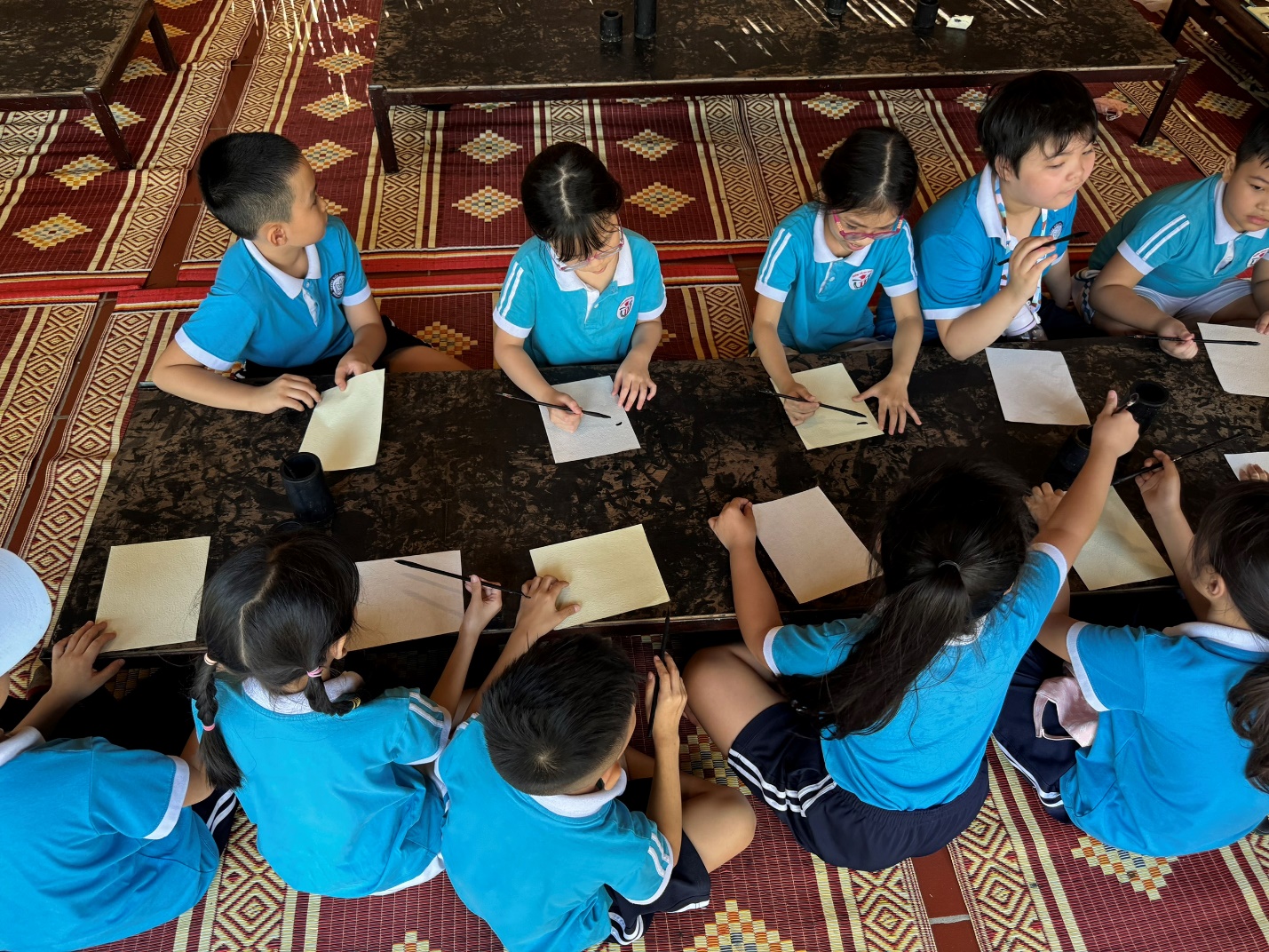 A group of children sitting around a table

Description automatically generated