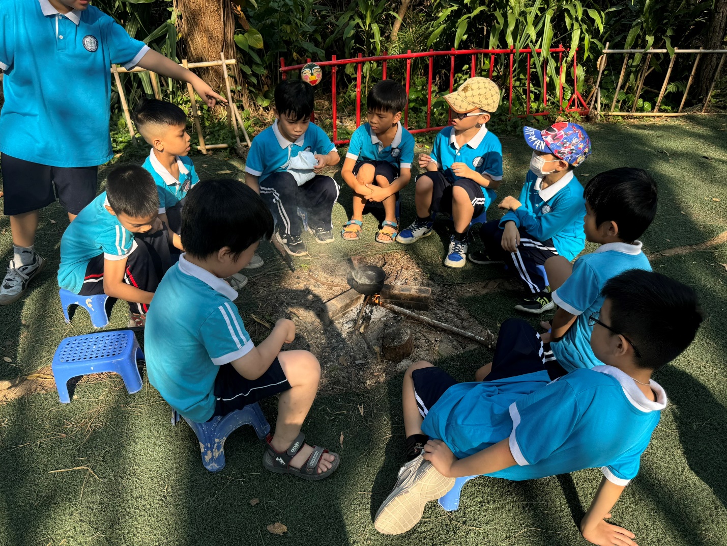A group of children sitting around a fire

Description automatically generated
