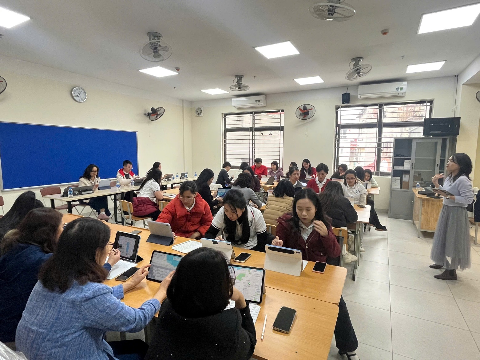 A group of people sitting at tables in a classroom
Description automatically generated