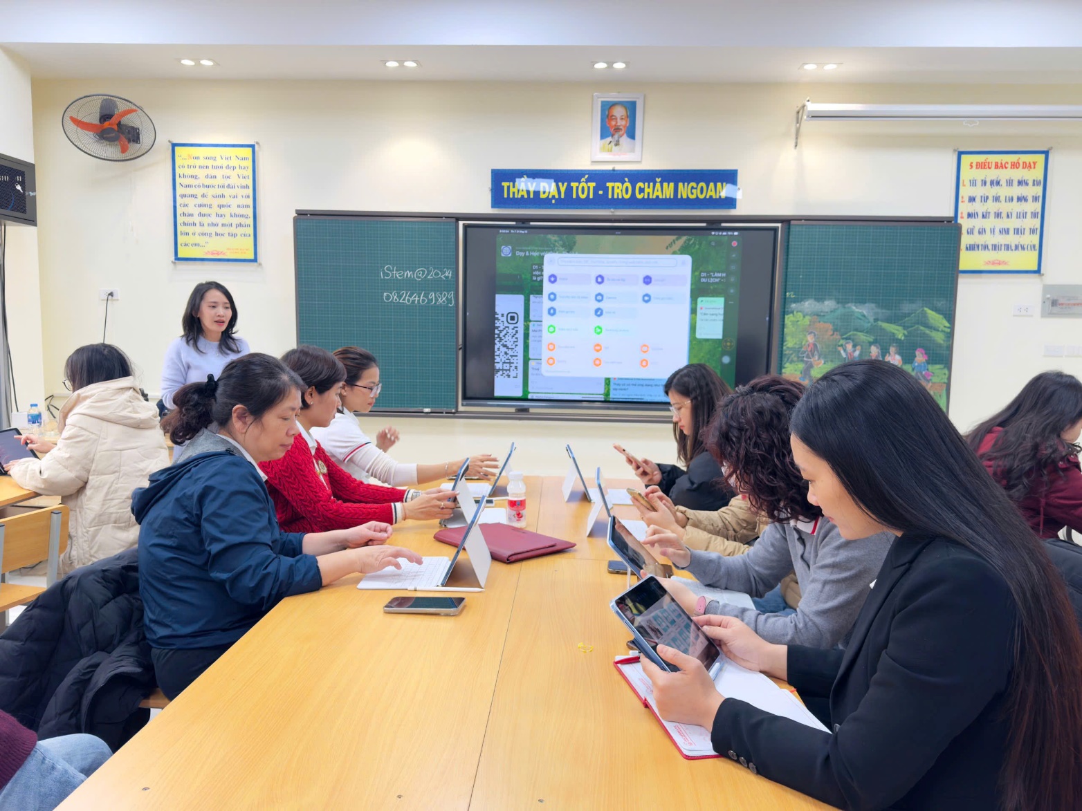 A group of people sitting at a table using their devices
Description automatically generated