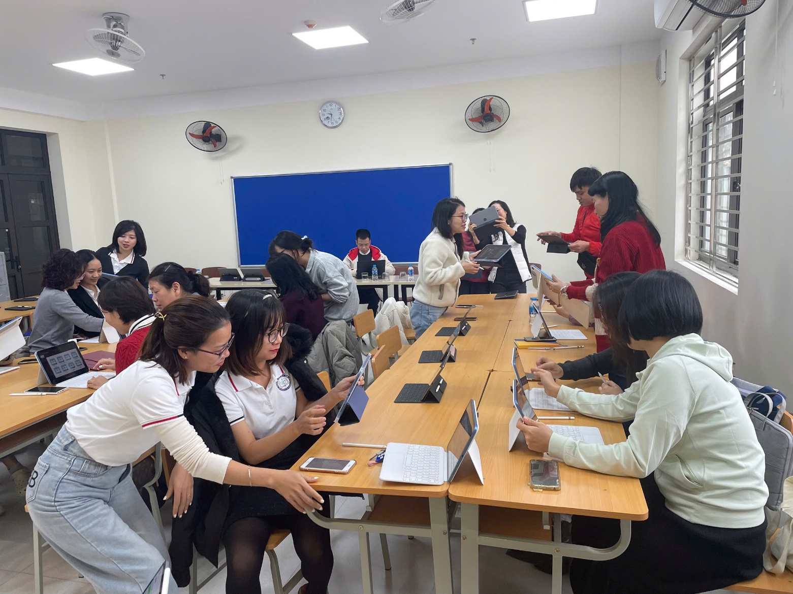 A group of people sitting at tables in a classroom
Description automatically generated