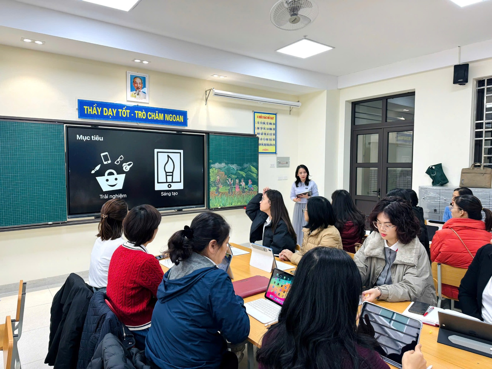 A group of people sitting at a table in a classroom
Description automatically generated