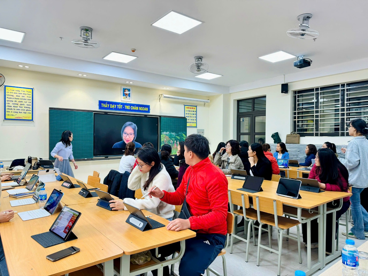 A group of people sitting at desks in a classroom
Description automatically generated
