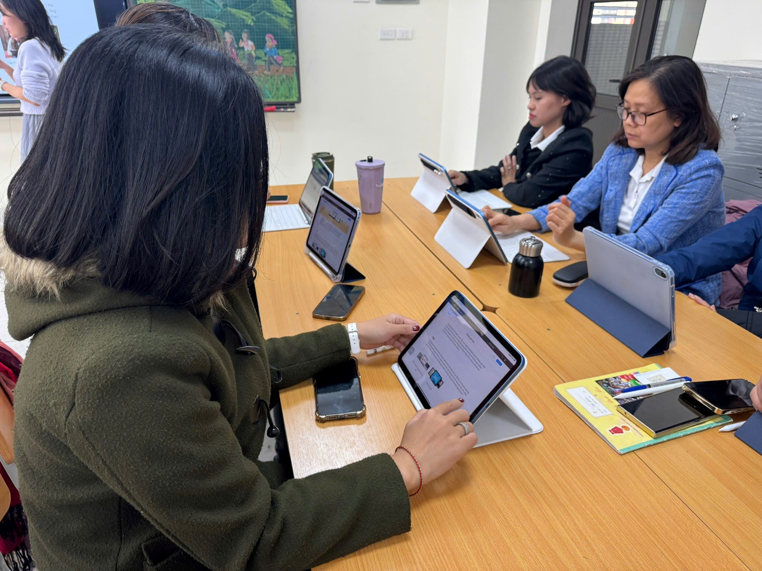 A group of people sitting at a table with laptops
Description automatically generated