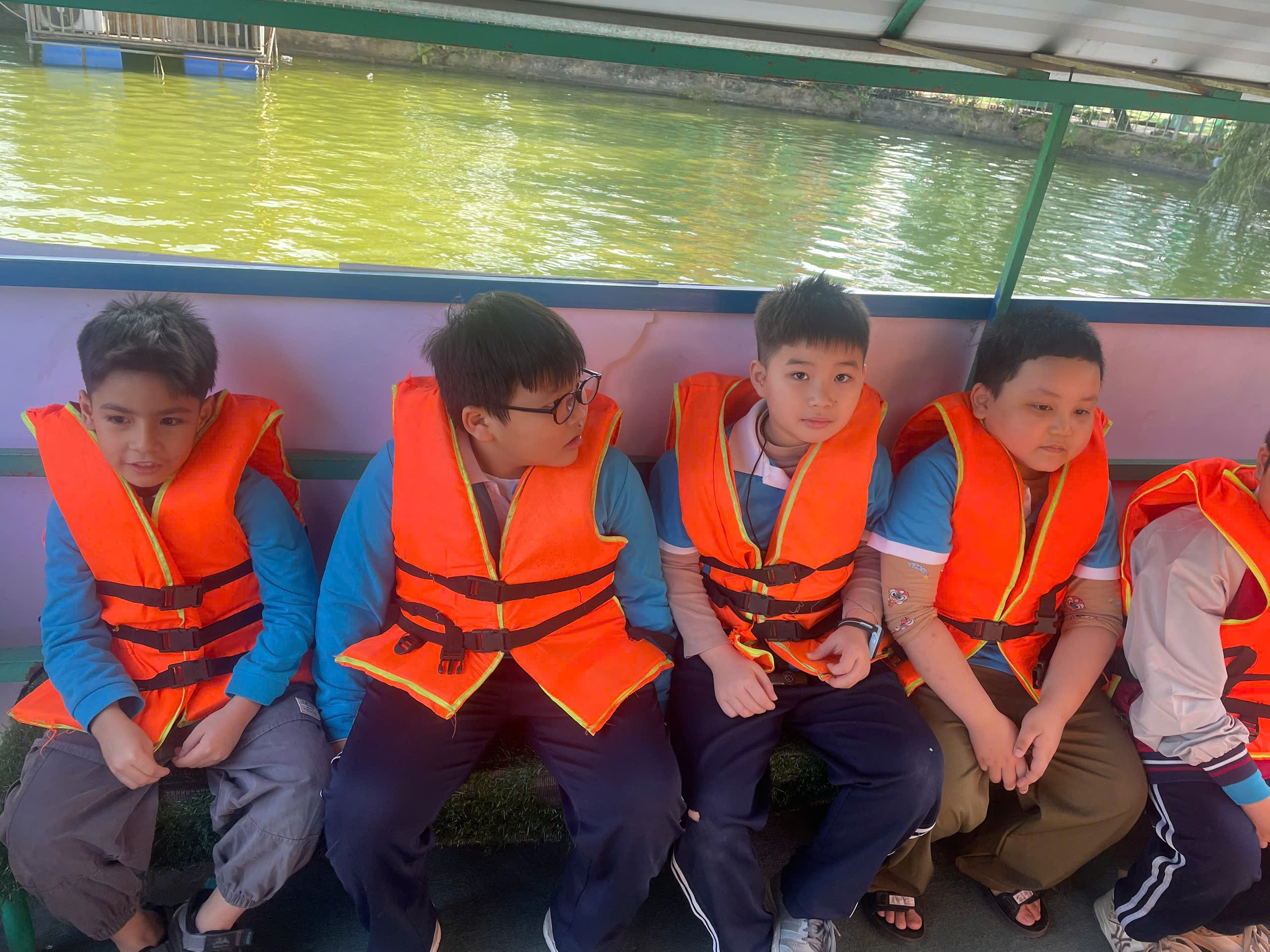 A group of boys wearing life jackets sitting on a boat
AI-generated content may be incorrect.