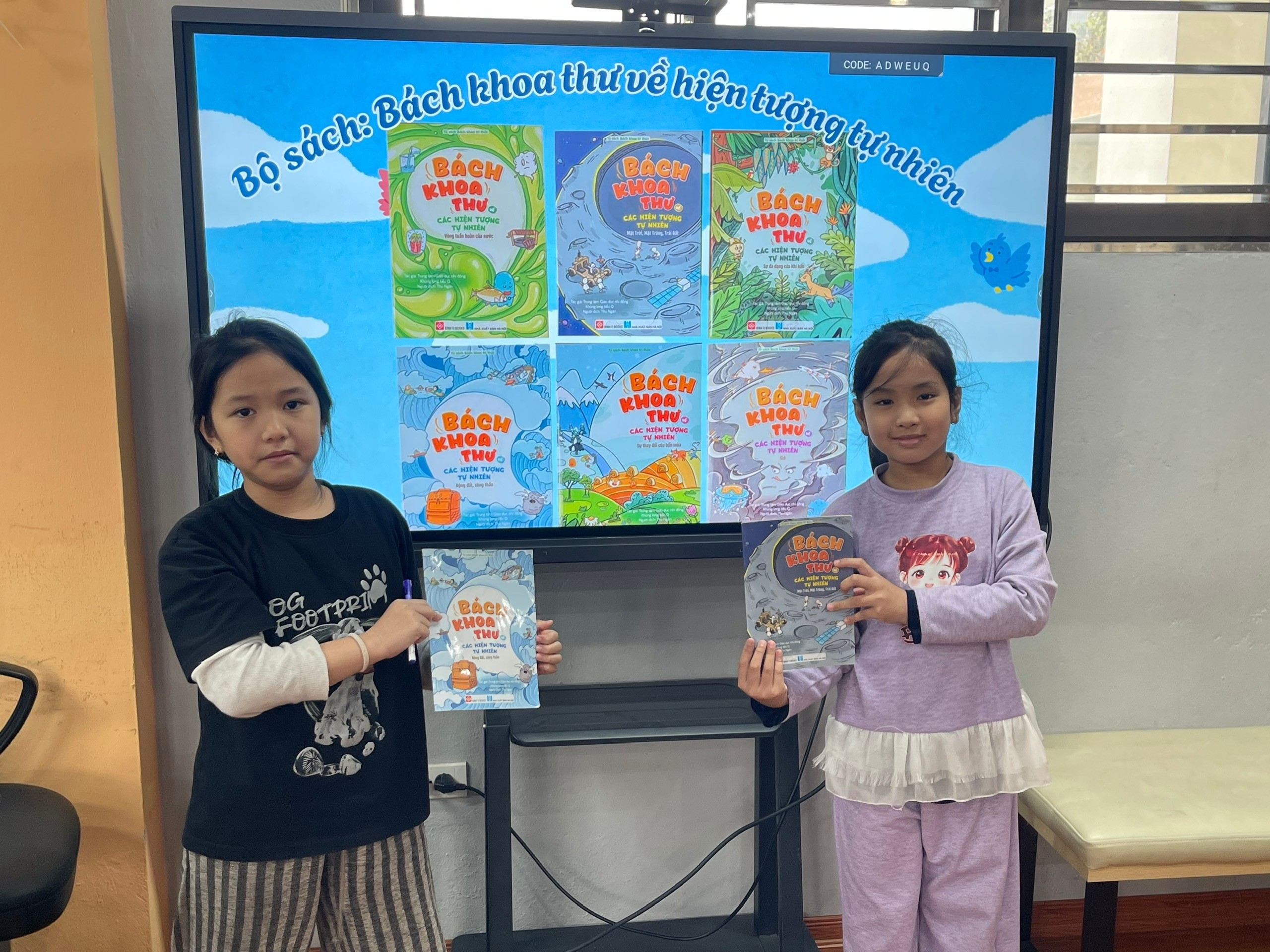 Two girls holding books in front of a large poster

AI-generated content may be incorrect.