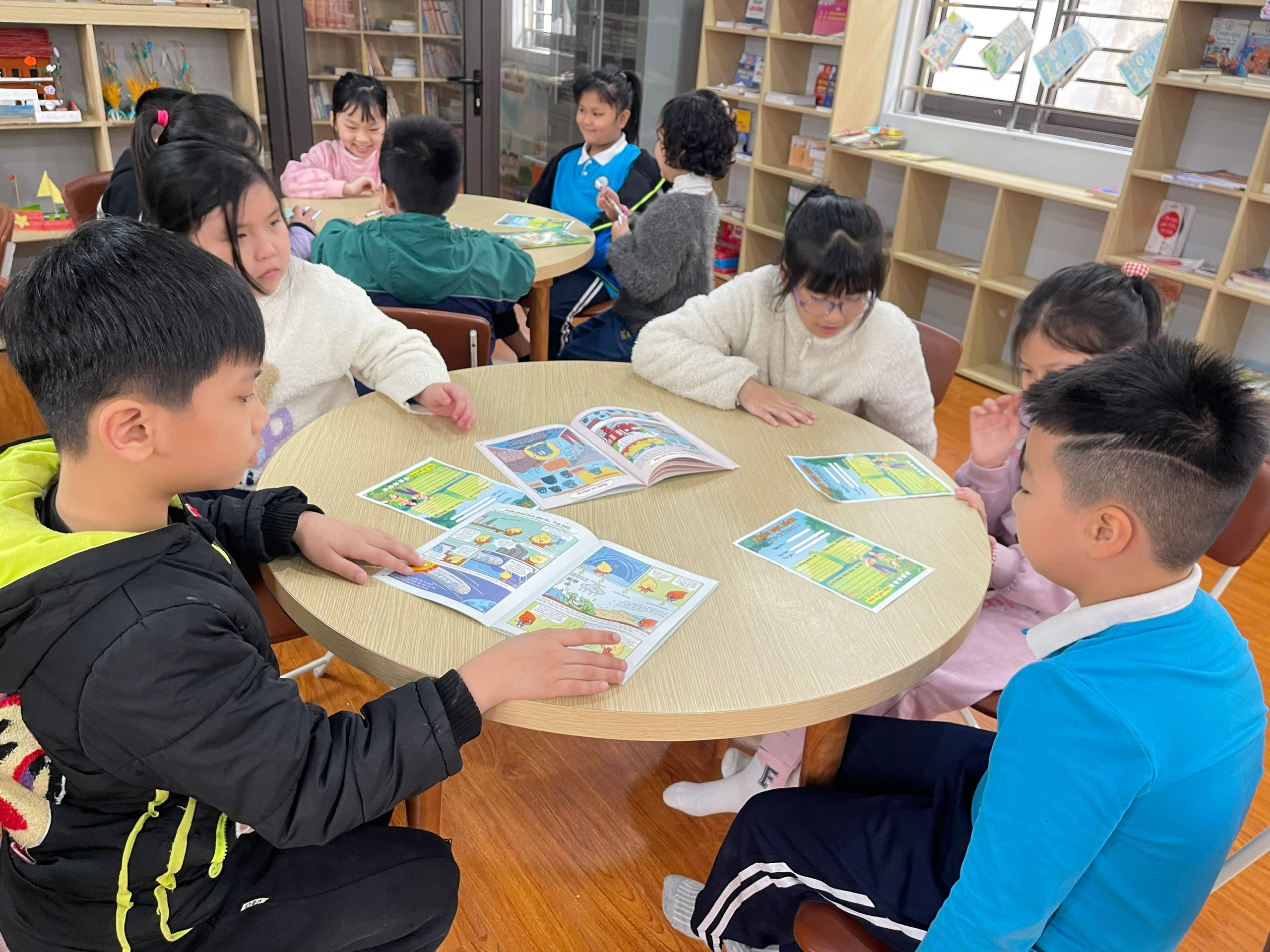 A group of children sitting at a round table reading books

AI-generated content may be incorrect.