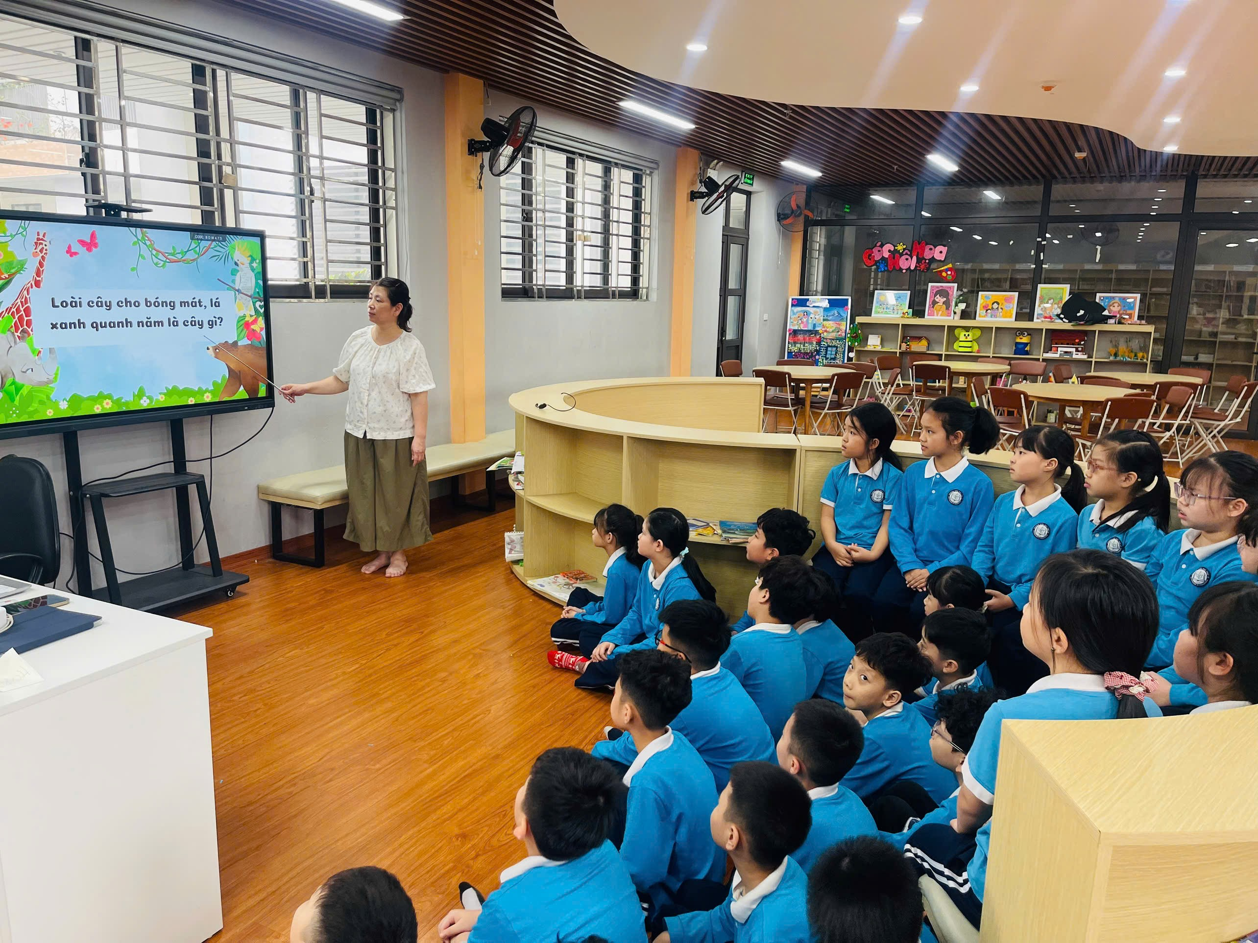 A person standing in front of a screen with a group of children sitting in front of them
AI-generated content may be incorrect.