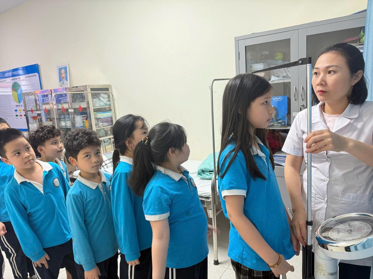 Nhân viên Y tế đo chiều cao và cân nặng cho học sinh cuối năm học 2025-2026